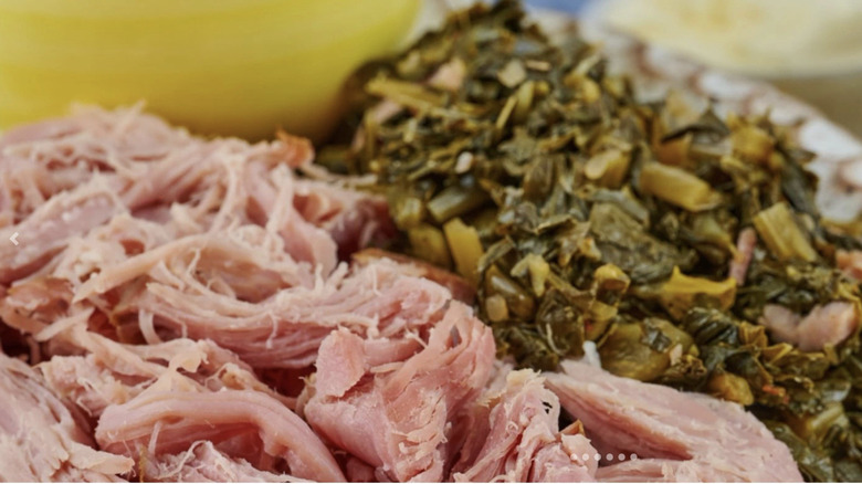Shredded pulled-pit ham and roasted turnip greens on a white plate