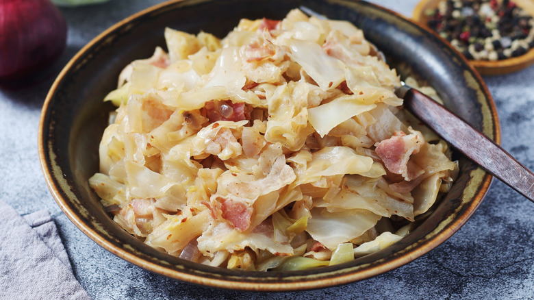a bowl of southern fried cabbage flecked with bacon bits