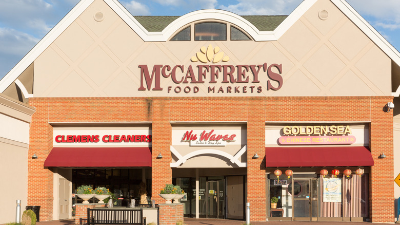 McCaffrey's Food Markets exterior with the store name in brown on a tan backdrop, above signs for a cleaners and a restaurant