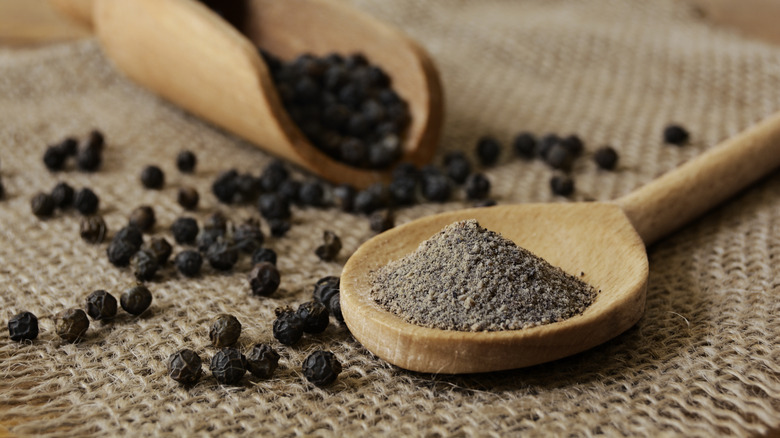 Black pepper and peppercorns on a wooden spoon