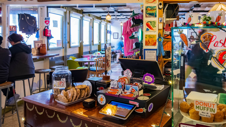 The eclectic interior of The Root Café in Little Rock, with hand-drawn signs and artwork on the walls.