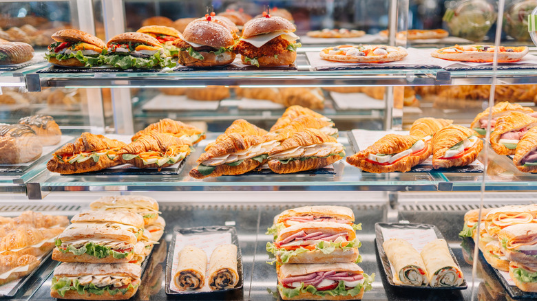 Deli case full of different types of sandwiches