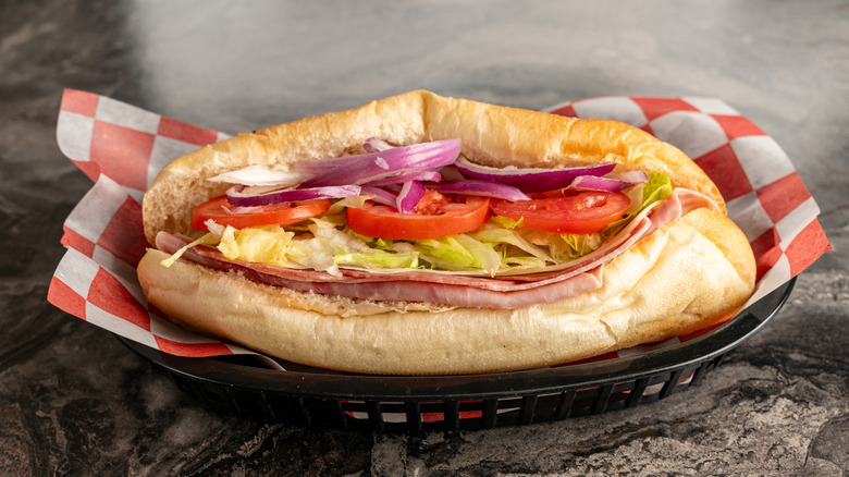 An Italian sub sandwich is diaplayed on red and white paper