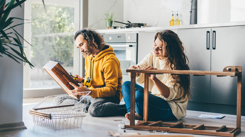 Couple assembling kitchen furniture