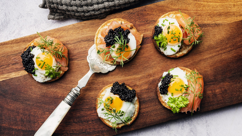 Blinis served with eggs, fish, herbs, and caviar