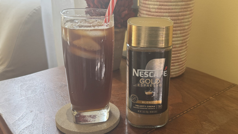 A glass of iced coffee on a table with Nescafe Gold Espresso package sitting next to it