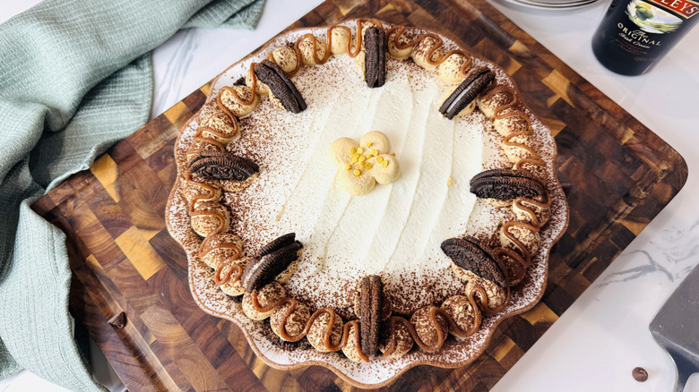 cream pie with brown decorations on a brown tray with a crumpled green napkin