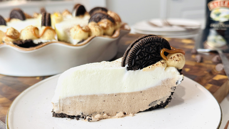 slice of cream pie with a chocolate sandwich cookie on a white plate
