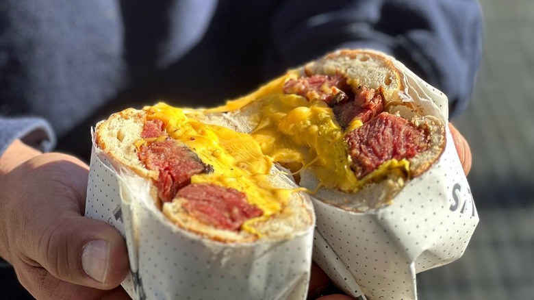A person holding a corned beef sandwich at Frankel's Delicatessen in Brooklyn