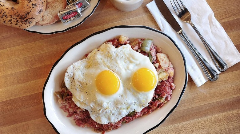 A plate of corned beef hash with eggs and bagels at Kenny & Ziggy's Delicatessen in Houston