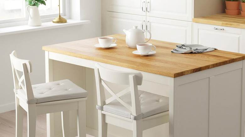 TORNVIKEN kitchen island staged with barstools and cups