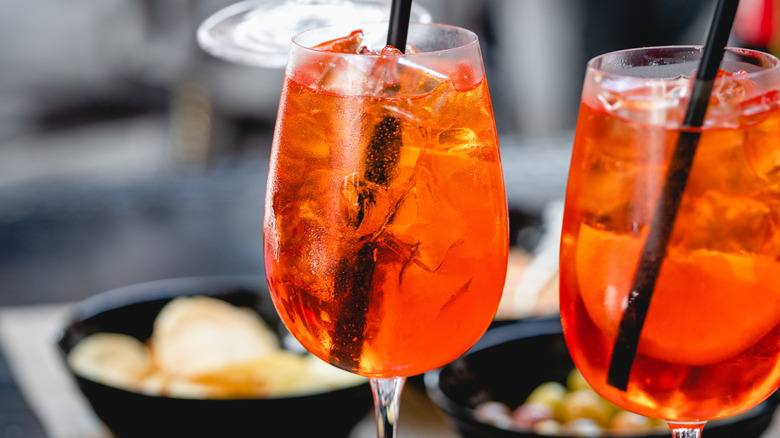 Bright orange spritz cocktails in stemmed glasses