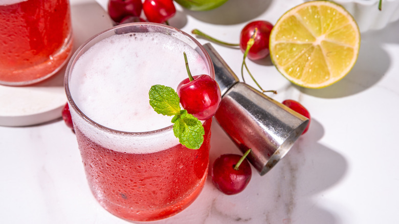Cherry margarita with fresh ingredients surrounding it