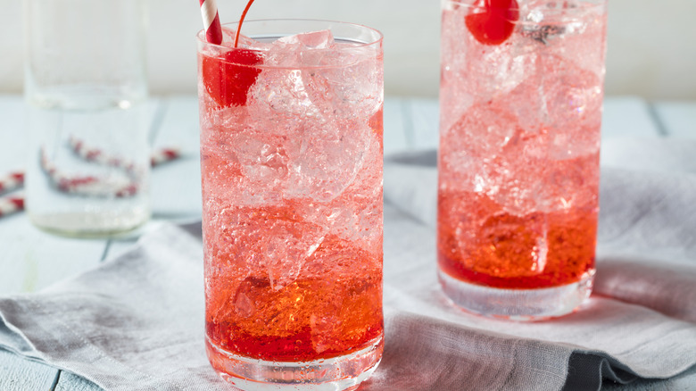 Two cherry soda cocktails on ice