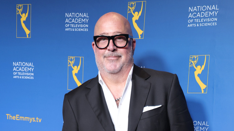Andrew Zimmern standing on a red carpet at the Emmy awards.