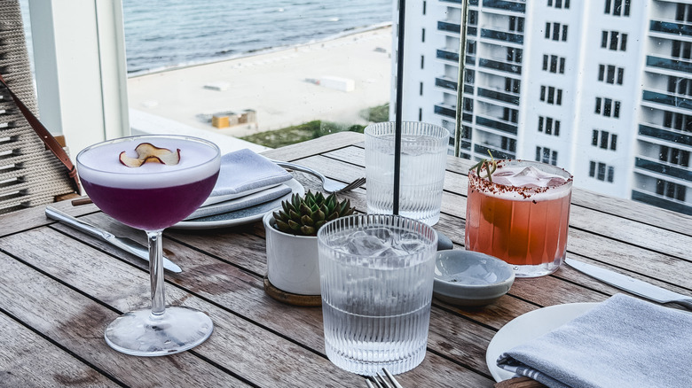 Cocktails on a table by the window overlooking the beack in Miami