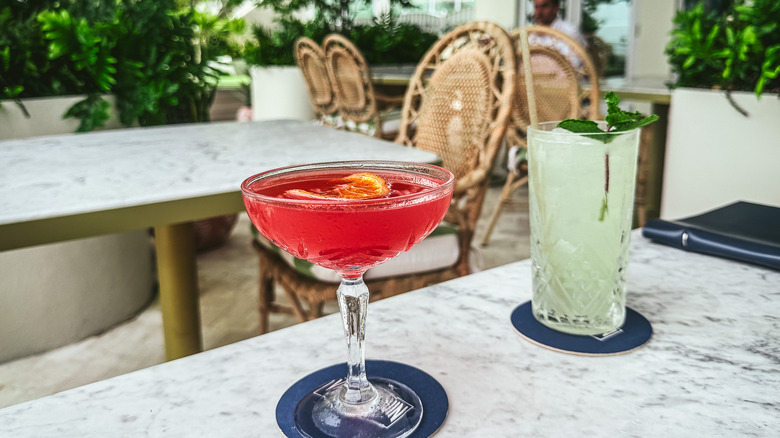 Two drinks flutes at Vilebrequin La Plage with bar in background