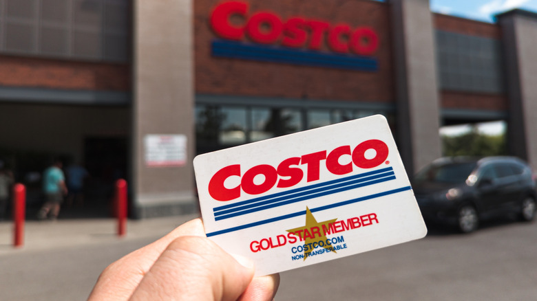 Costco Card in front of a Costco Warehouse
