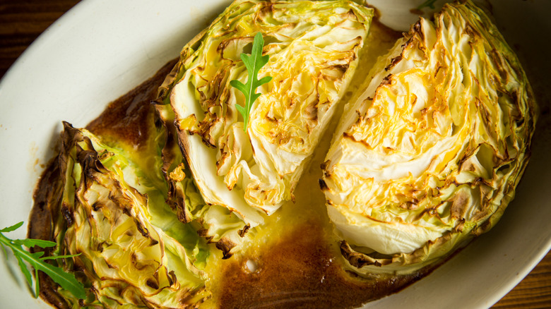 roasted cabbage served on white dish on top of browned sauce.