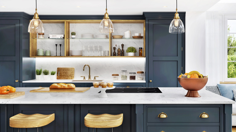 a kitchen with blue cabinets and gold accents