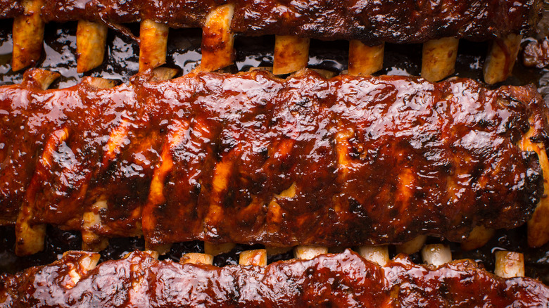 Top-down view of racks of saucy, smoked baby back ribs