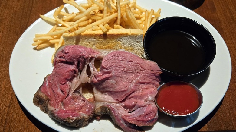 J Alexander's prime rib sandwich served with fries, au jus, and ketchup