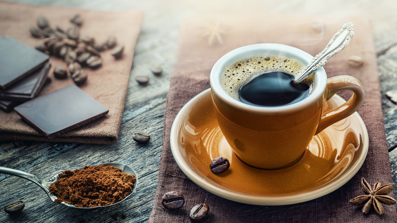 A cup of espresso with coffee beans