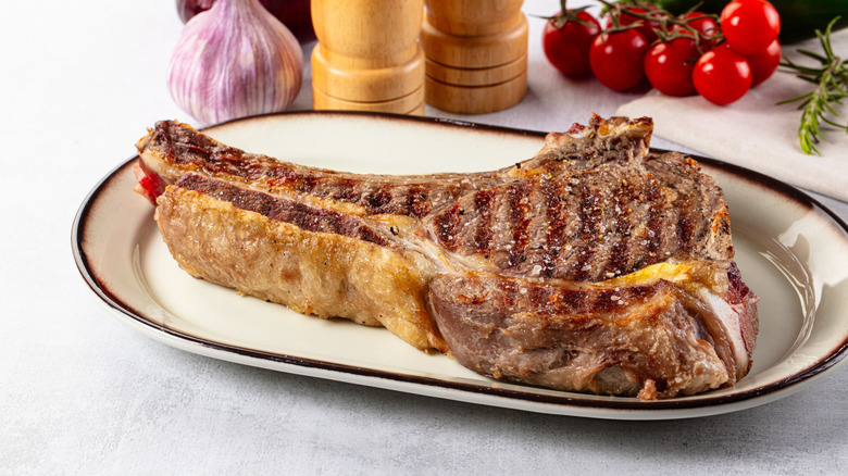 Grilled ribeye steak with bone and marbling.