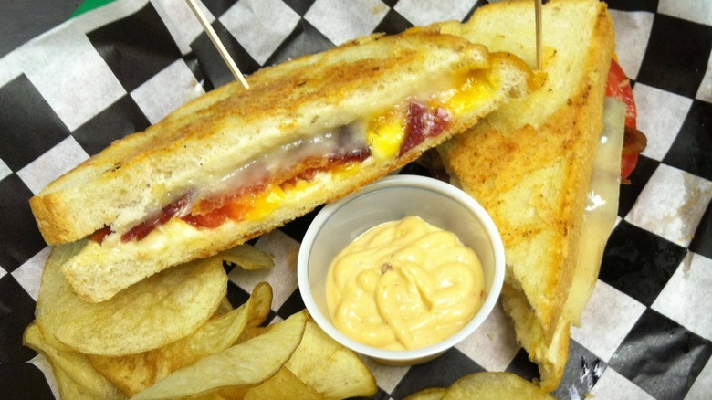 A grilled sandwich with a side of chips