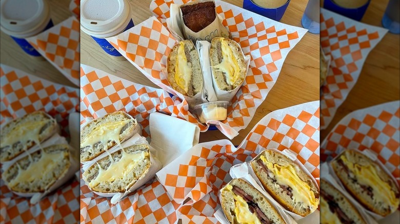 A table with sandwiches, sides, and drinks
