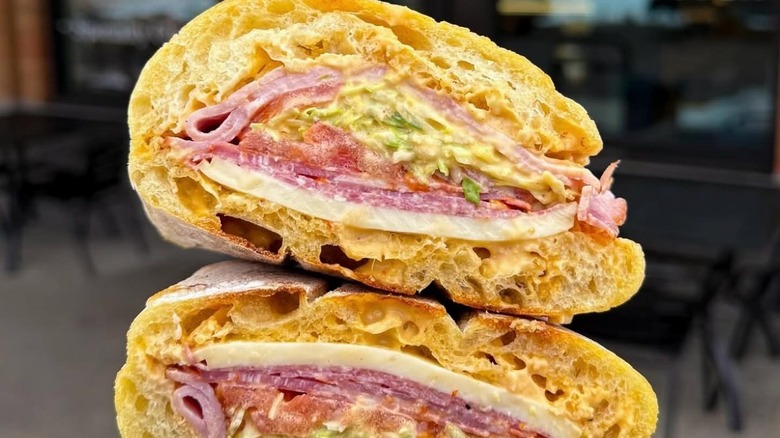A sandwich close-up with tables and chairs in the background
