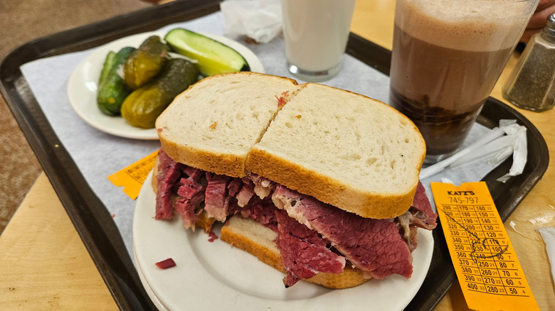 Corned beef sandwich and pickles on a tray