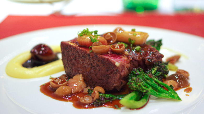 steak with burgundy mushroom sauce on plate with broccoli
