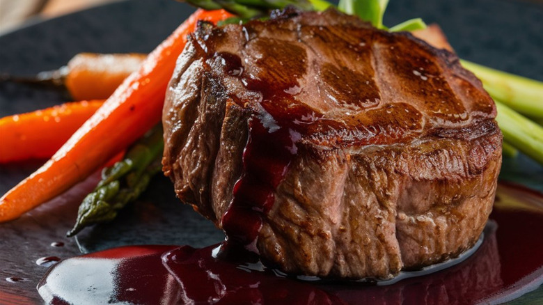 steak with red wine sauce, carrots, and asparagus