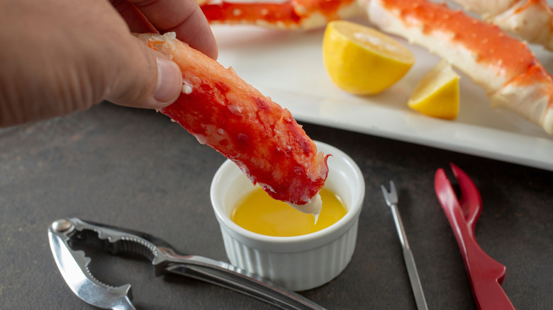 Dipping crab leg into a cup of garlic butter
