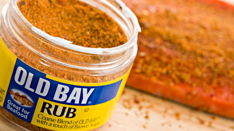 Container of Old Bay seasoning with seasoned fish