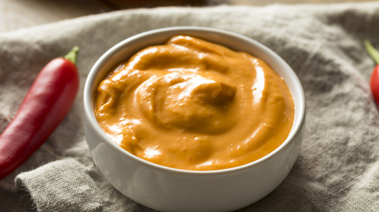 Spicy aioli in a white bowl on linen cloth