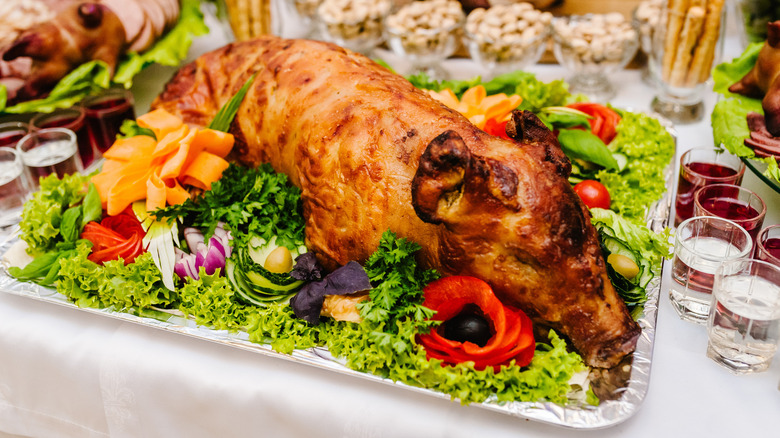 A roasted lechon pork with sauce and garnishes