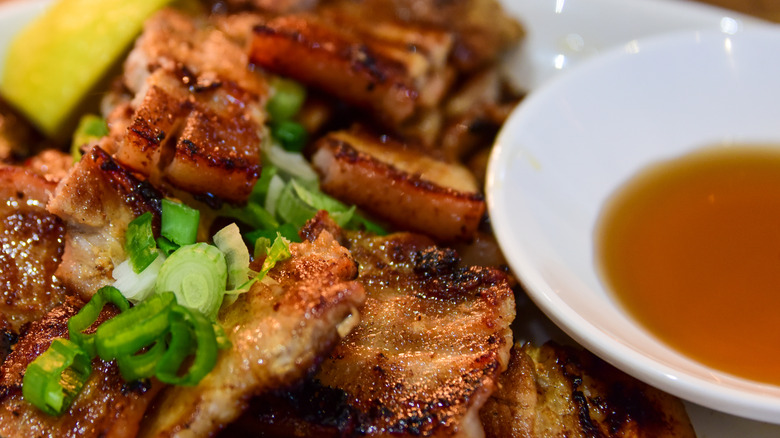 Crispy pork belly with a bowl of vinegar dipping sauce