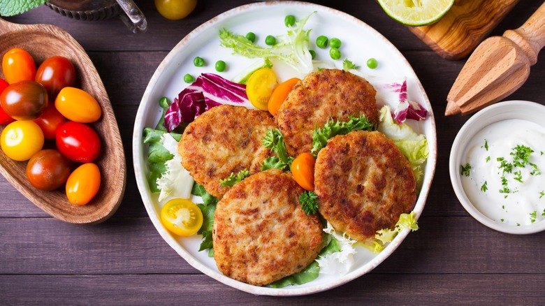 salmon patties served with fresh vegetables and tartar sauce