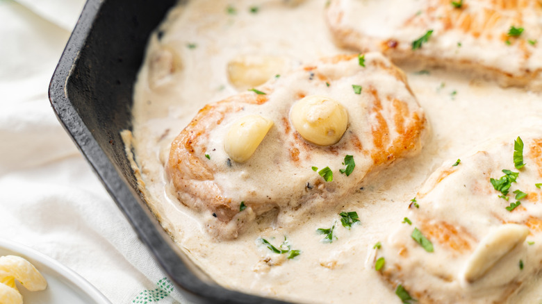 Pan of creamy pork chops in white sauce.
