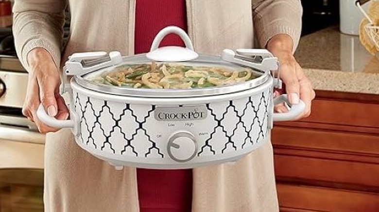 Woman holding the Crock-Pot Manual 2.5-Quart Casserole Slow Cooker