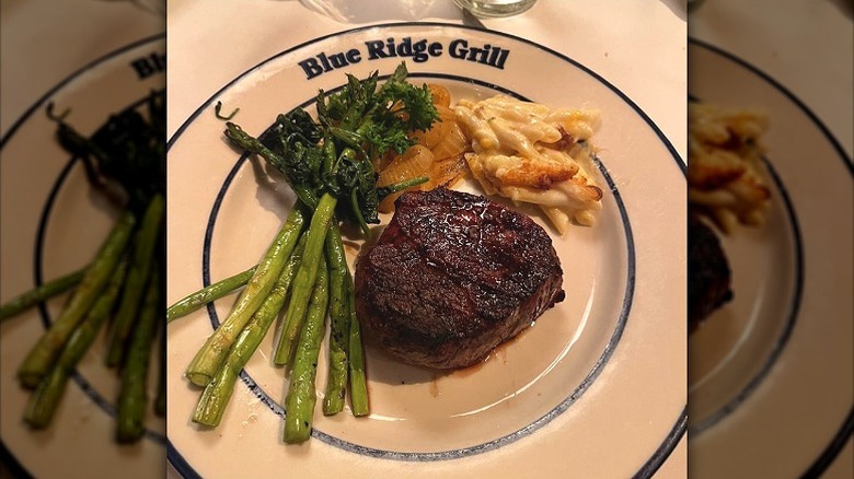 A cooked steak from The Blue Ridge Grill in Atlanta next to a sliced onion
