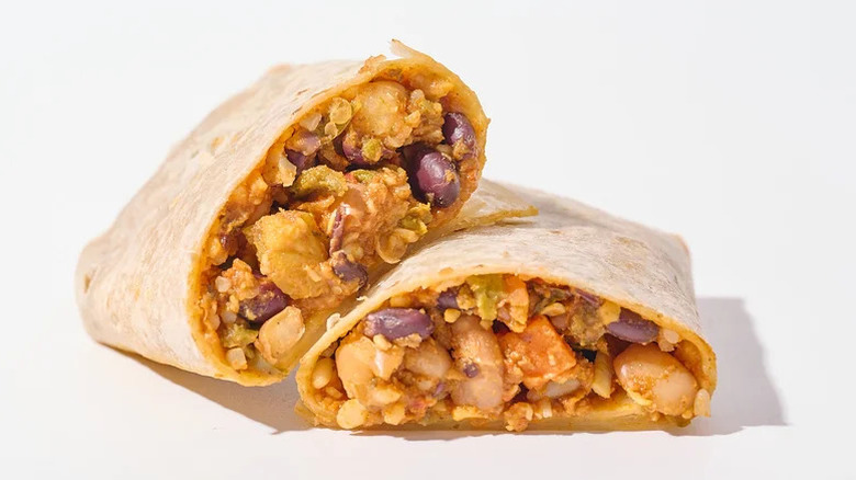 Burrito sliced in half revealing pinto beans, rice, and flour tortillas