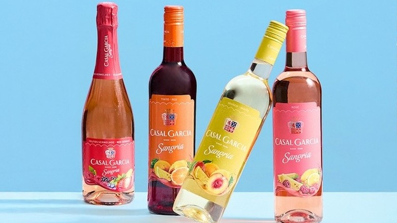Four bottles of Casal Garcia standing upright in front of a blue background