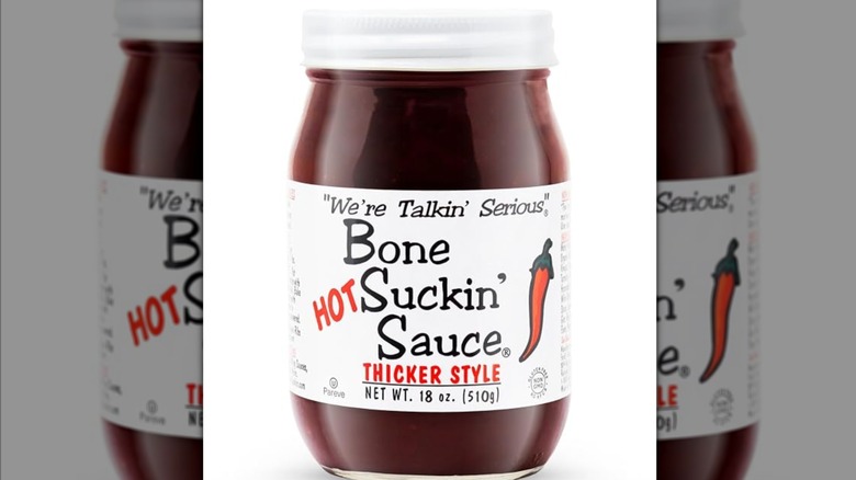 A jar of Bone Suckin' Sauce Hot Thicker Style on a white background