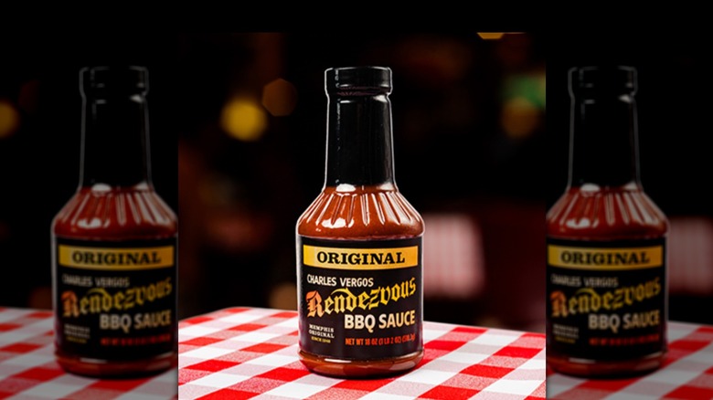 A bottle of Charles Vergos Rendezvous Original BBQ Sauce on a table with a white and red checkered table cloth