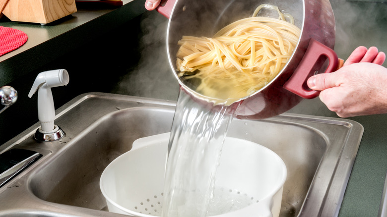 Draining fettuccine in colander