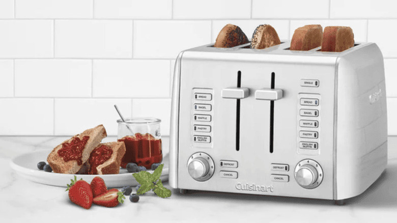 Silver Cuisinart 4 slice toaster sitting on a countertop next to plate of toast and berries
