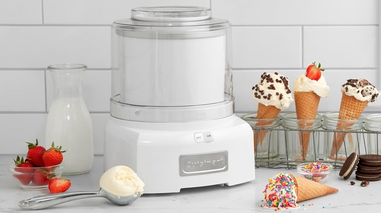 White Cuisinart ice cream maker sitting on a table next to ice cream